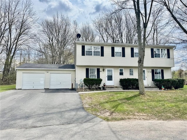colonial home featuring a garage, driveway, a front yard, and entry steps