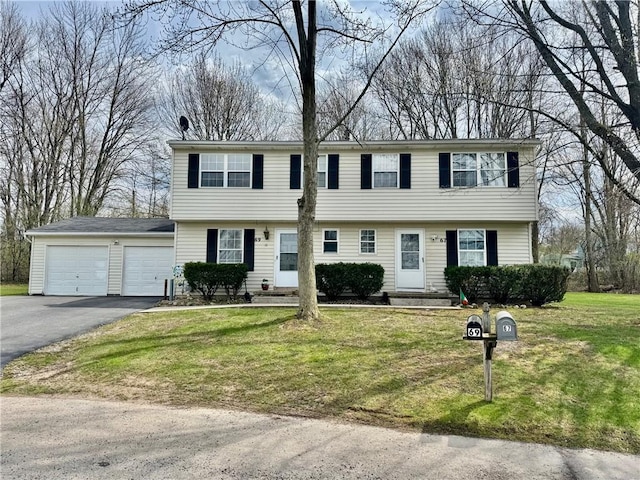 colonial-style house with driveway, a front yard, and entry steps