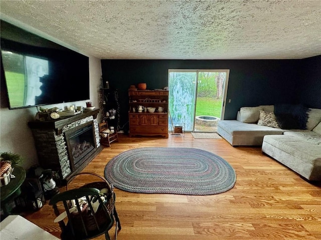living area with a textured ceiling, wood finished floors, and a fireplace