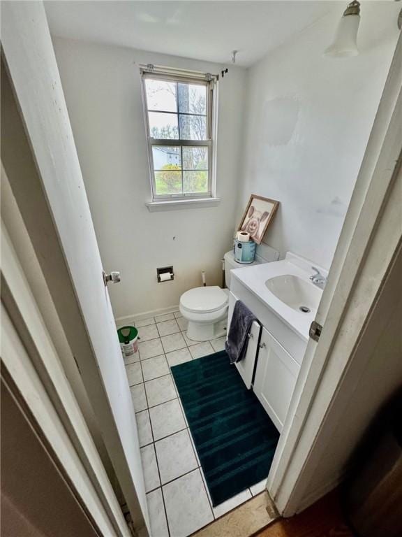 bathroom with vanity, baseboards, tile patterned floors, and toilet