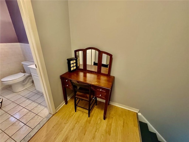 interior space featuring baseboards, wood finished floors, and toilet