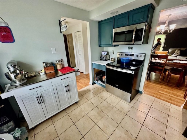 kitchen featuring a notable chandelier, appliances with stainless steel finishes, and light tile patterned floors