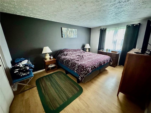 bedroom featuring a textured ceiling and wood finished floors
