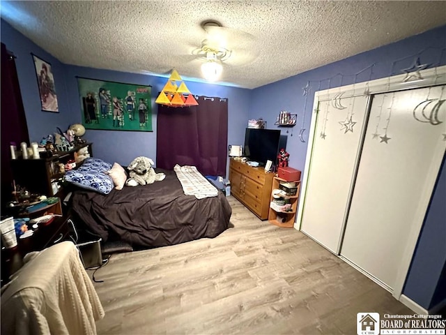 bedroom with a textured ceiling and light wood-style floors