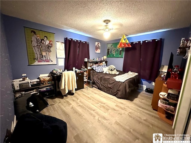 bedroom featuring a textured ceiling and wood finished floors