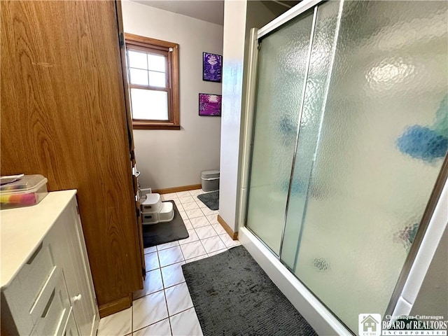 bathroom with baseboards, tile patterned floors, a stall shower, and toilet