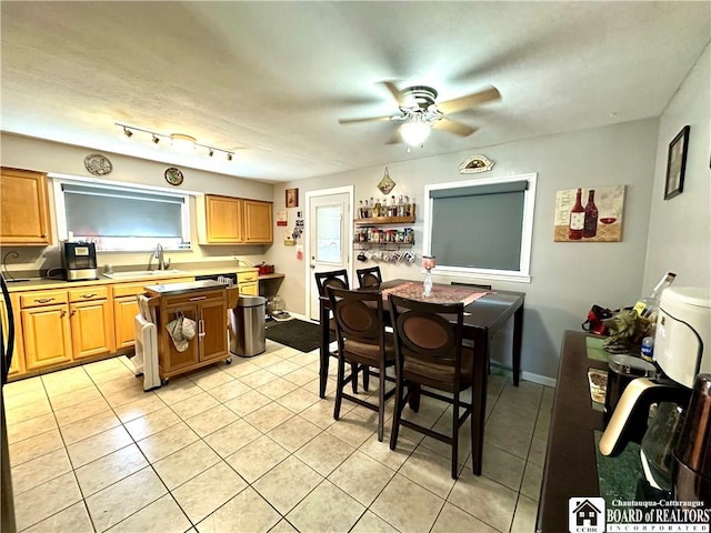 kitchen featuring a sink, ceiling fan, light tile patterned floors, and light countertops
