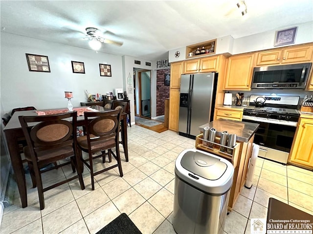 kitchen featuring light tile patterned floors, light brown cabinetry, ceiling fan, and stainless steel appliances