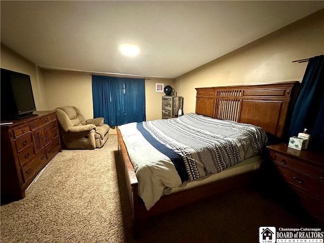 carpeted bedroom with lofted ceiling