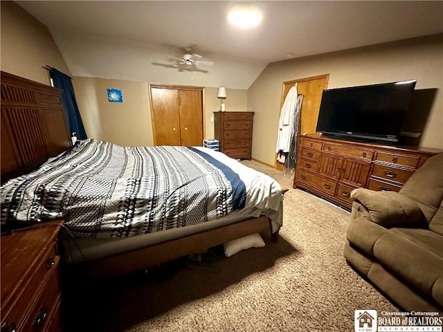 bedroom featuring a closet, a ceiling fan, light carpet, and vaulted ceiling