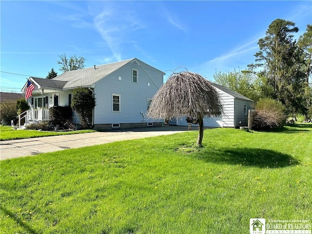 view of side of property featuring a yard, driveway, and covered porch