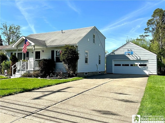 view of front of house featuring a garage, an outbuilding, driveway, and a front lawn