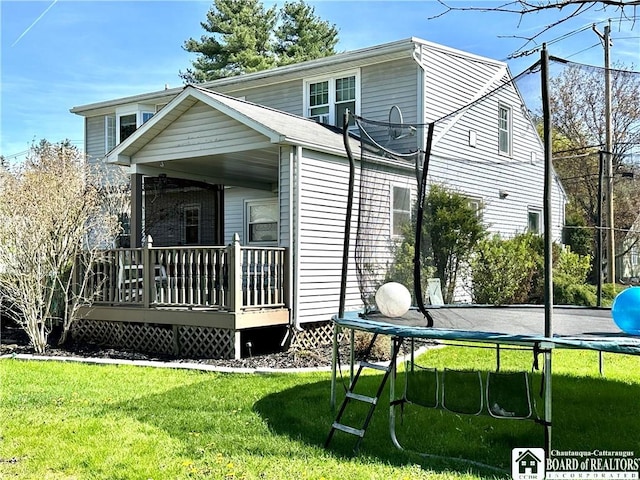 exterior space with a trampoline, a yard, and a deck