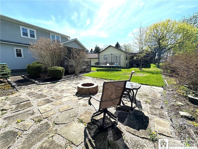 view of patio / terrace with a trampoline and a fire pit