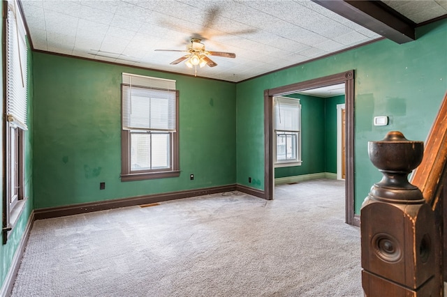 unfurnished room with crown molding, visible vents, baseboards, ceiling fan, and carpet flooring