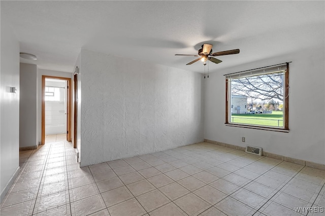 unfurnished room featuring light tile patterned floors, a ceiling fan, and visible vents