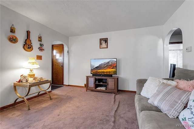 carpeted living area with arched walkways and baseboards