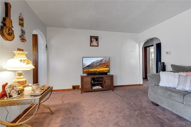 carpeted living room featuring baseboards, arched walkways, and visible vents