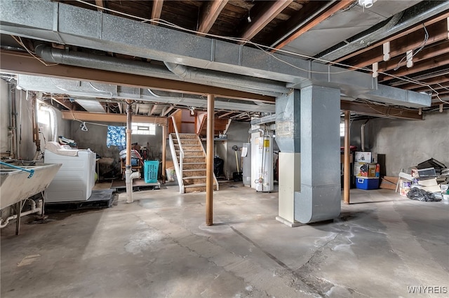 basement featuring heating unit, stairs, washer and dryer, a sink, and water heater