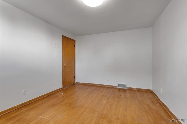 unfurnished room featuring light wood-style floors, baseboards, and visible vents