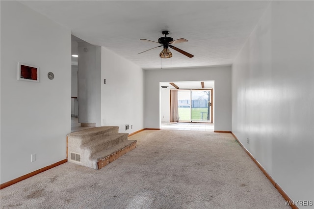 unfurnished living room with visible vents, a ceiling fan, baseboards, and carpet flooring