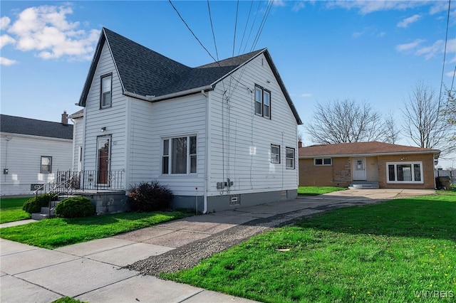 traditional home featuring a shingled roof and a front yard