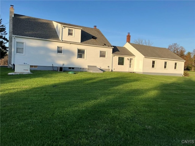 back of property featuring a lawn and a chimney
