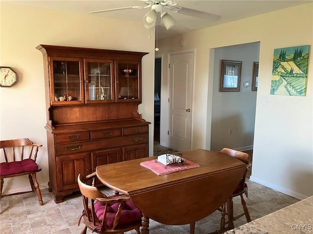dining area with baseboards and ceiling fan