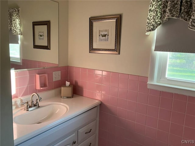 bathroom with tile walls, a wainscoted wall, and vanity