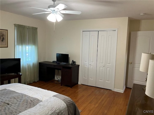 bedroom with baseboards, a ceiling fan, a closet, and wood finished floors