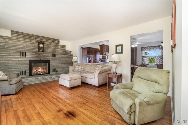 2203 State Route 90th Rd, Ledyard, NY 13026 - living area with a fireplace, light wood-style flooring, and a ceiling fan