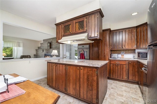 2203 State Route 90th Rd, Ledyard, NY 13026 - kitchen with appliances with stainless steel finishes, a fireplace, tasteful backsplash, a center island, and under cabinet range hood