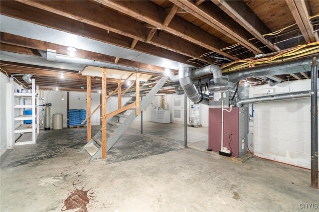 2203 State Route 90th Rd, Ledyard, NY 13026 - unfinished below grade area with gas water heater, stairs, heating unit, and washer and clothes dryer