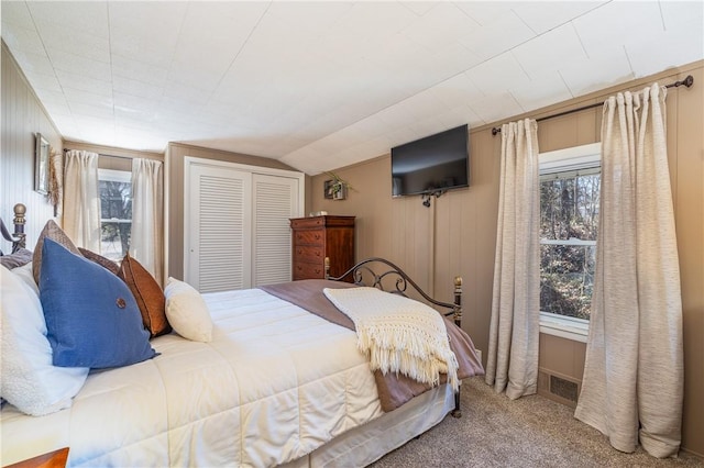 bedroom featuring vaulted ceiling, visible vents, carpet, and a closet