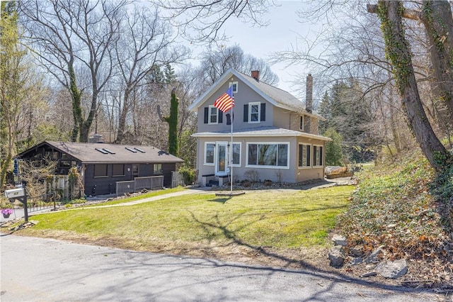 view of front of property with a chimney, stucco siding, and a front yard
