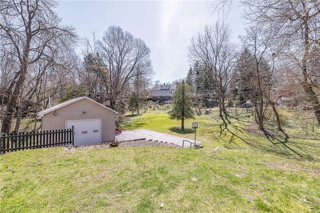 view of yard featuring an outdoor structure, fence, and a detached garage