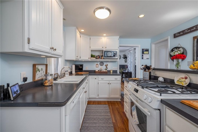 kitchen featuring white cabinets, dark countertops, open shelves, a sink, and white appliances
