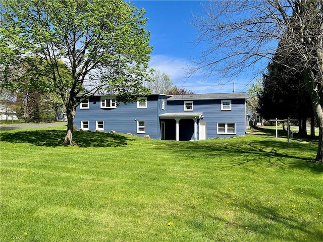 back of property with a lawn