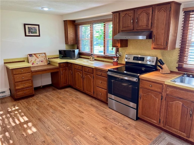 kitchen with stainless steel electric stove, plenty of natural light, under cabinet range hood, and light wood-style flooring