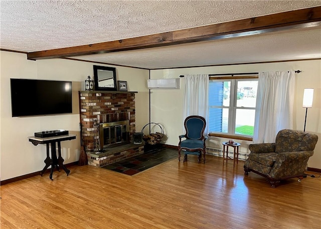 sitting room with a wall mounted air conditioner, a textured ceiling, wood finished floors, beamed ceiling, and a baseboard heating unit