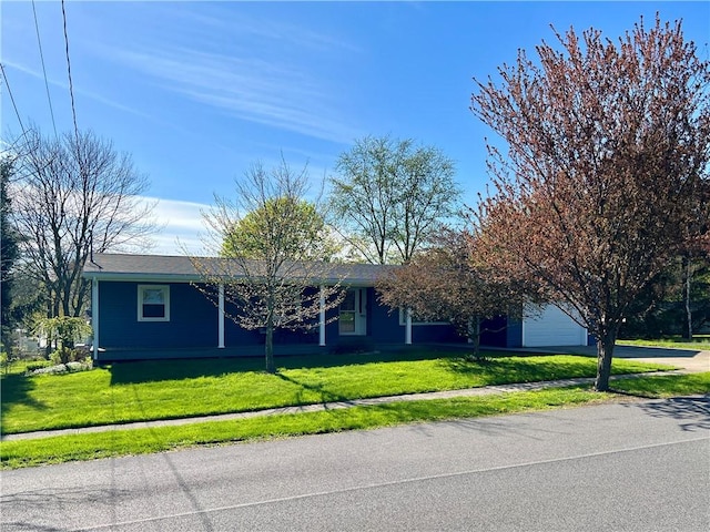 ranch-style house with concrete driveway, an attached garage, and a front lawn