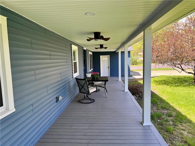 wooden terrace with a porch, a lawn, and ceiling fan