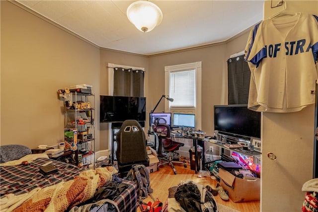 bedroom featuring ornamental molding and wood finished floors