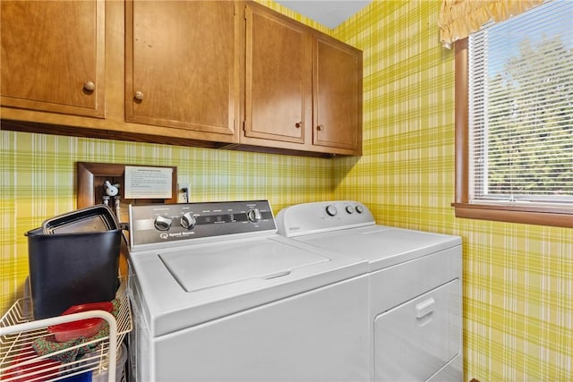 laundry area featuring wallpapered walls, cabinet space, and washer and dryer