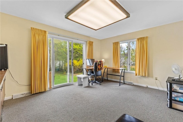 carpeted office featuring visible vents, baseboards, and a healthy amount of sunlight