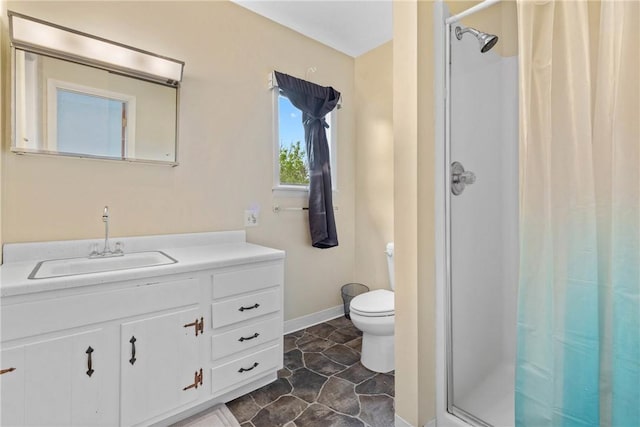 full bath featuring vanity, baseboards, a stall shower, and toilet