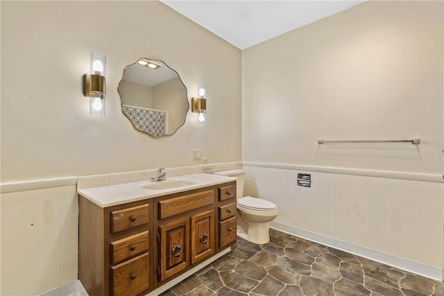 full bathroom featuring vanity, a shower with curtain, toilet, and stone finish flooring