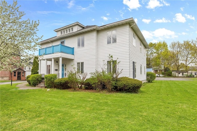 exterior space featuring a lawn and a balcony