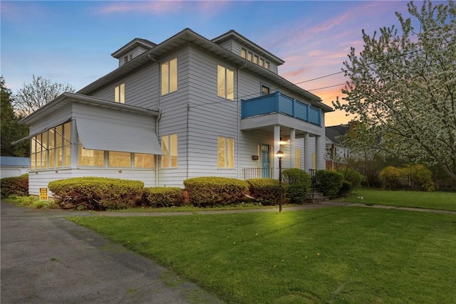view of front of home featuring a balcony and a front yard