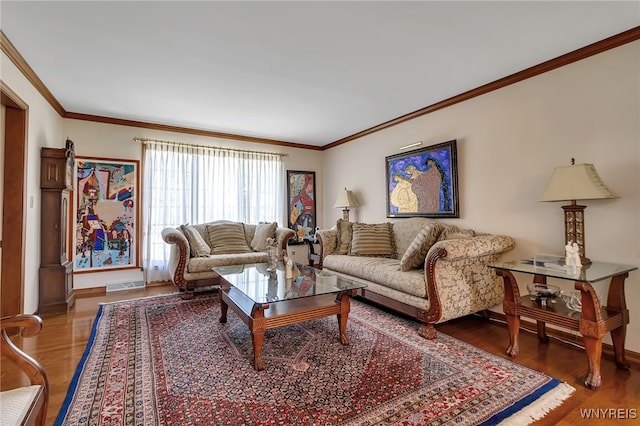 living area with visible vents, ornamental molding, light wood finished floors, and baseboards